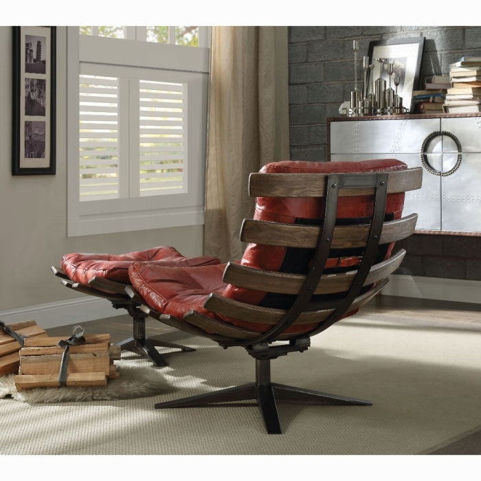 Red leather chair with wooden frame in a room with a window and shelves.