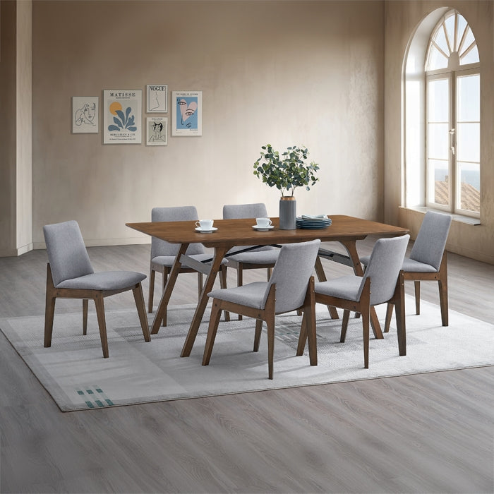 white background wood walnut look finish angled legs four of them straight rectangular top frame staged in a dinning setting with matching chairs with grey fabric plants photos rug and a window 