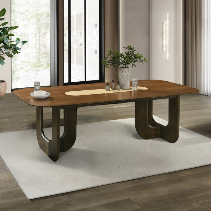 Wooden dining table in a modern room with large windows and plants.