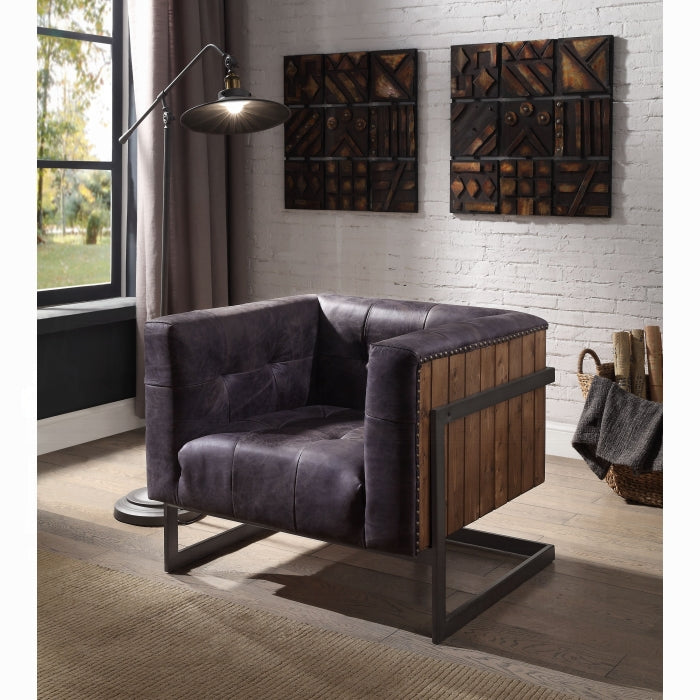Modern living room with a dark leather armchair, floor lamp, and decorative wall art.
