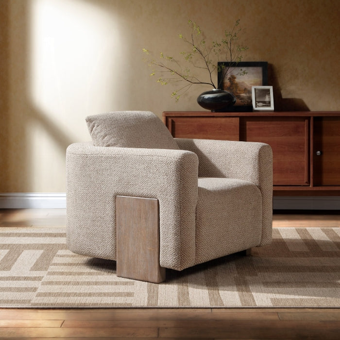 Beige armchair in a living room with wooden cabinet and decorative items.