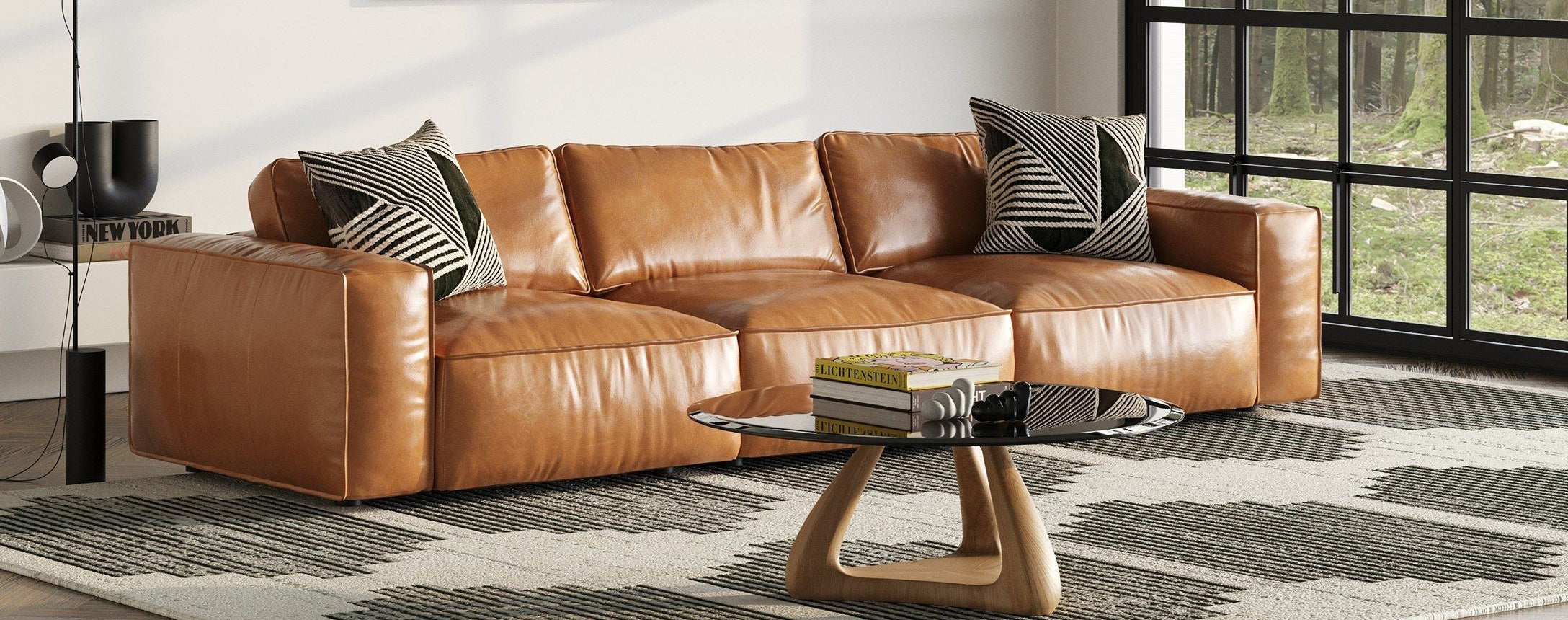 Modern living room with a brown leather sectional sofa, abstract art, and a large window.