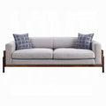 Gray sofa with wooden frame and blue patterned cushions on a white background