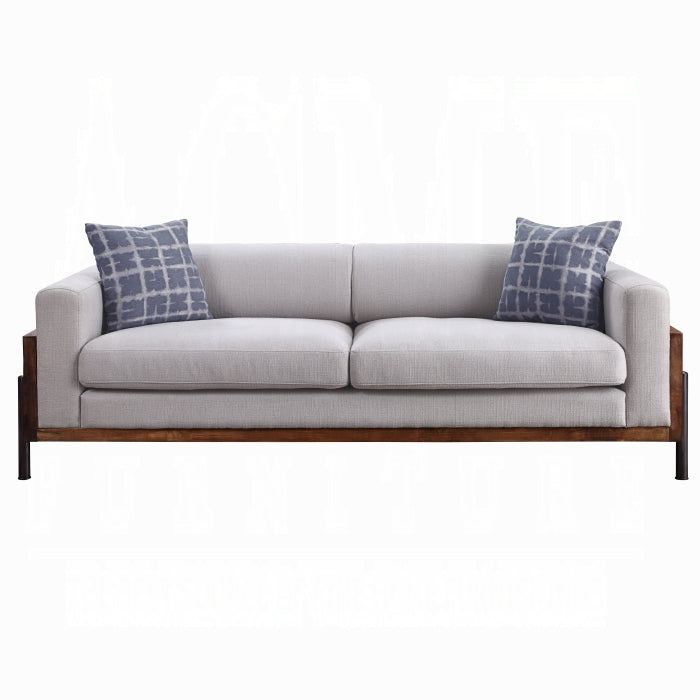 Gray sofa with wooden frame and blue patterned cushions on a white background